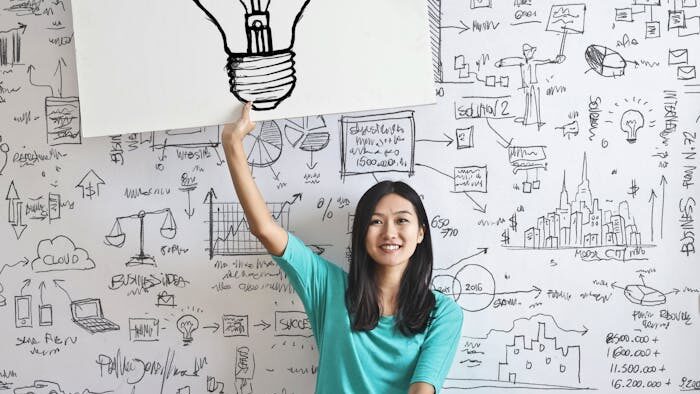 Woman Draw a Light bulb in White Board